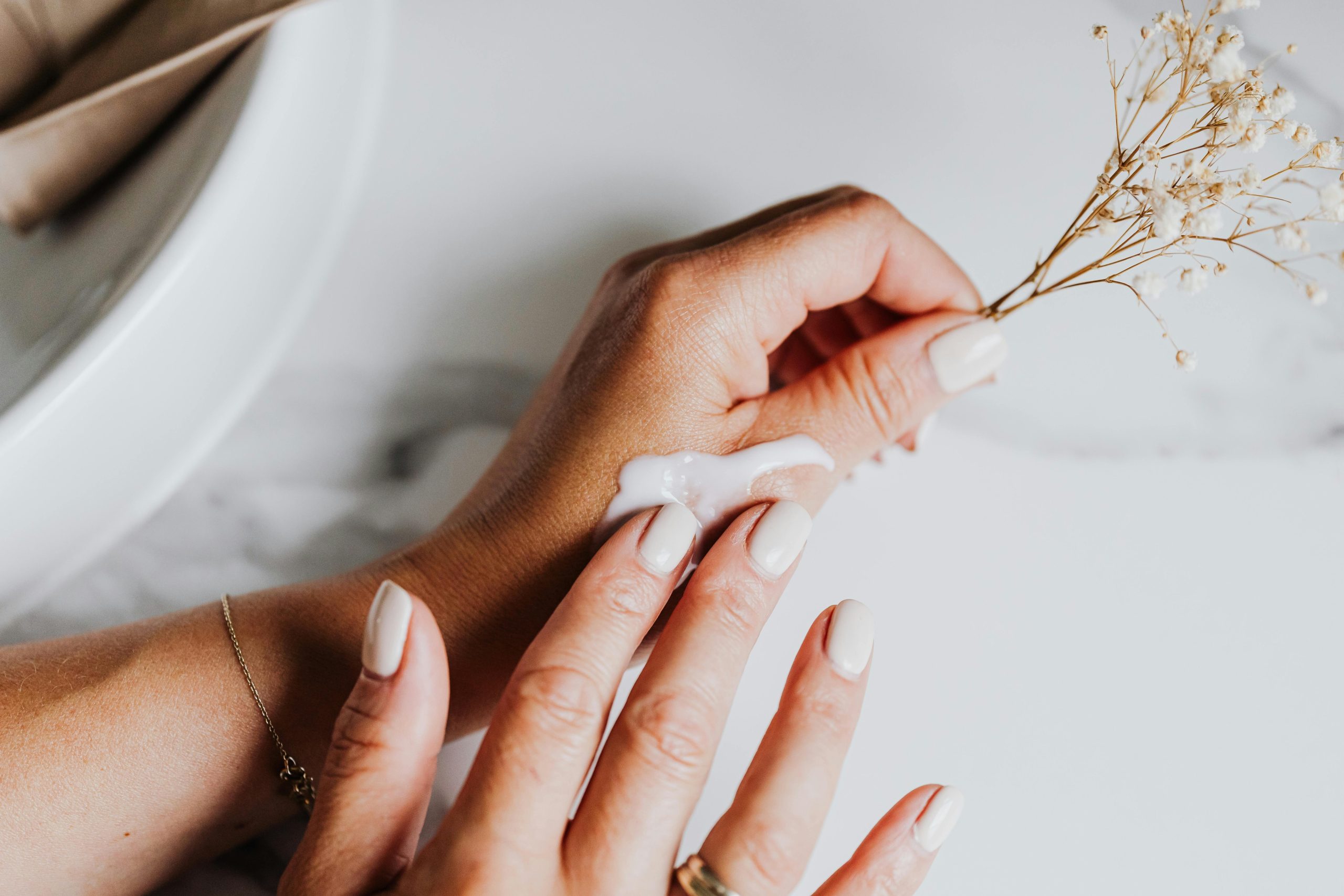A closeup of a woman applying light foundation with her fingers