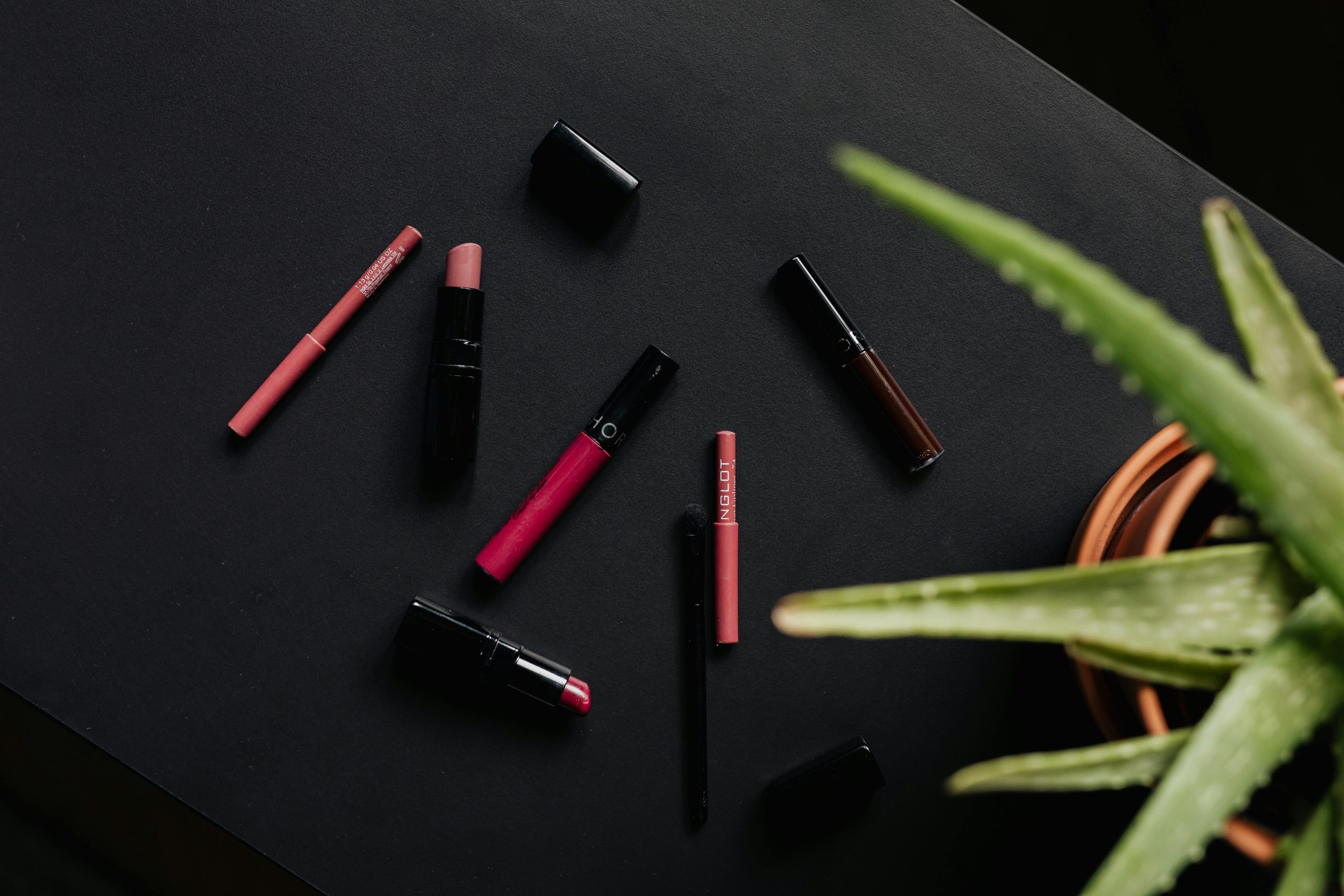 A collection of green makeup products including blushes, eyeshadows, and lipsticks made from natural ingredients