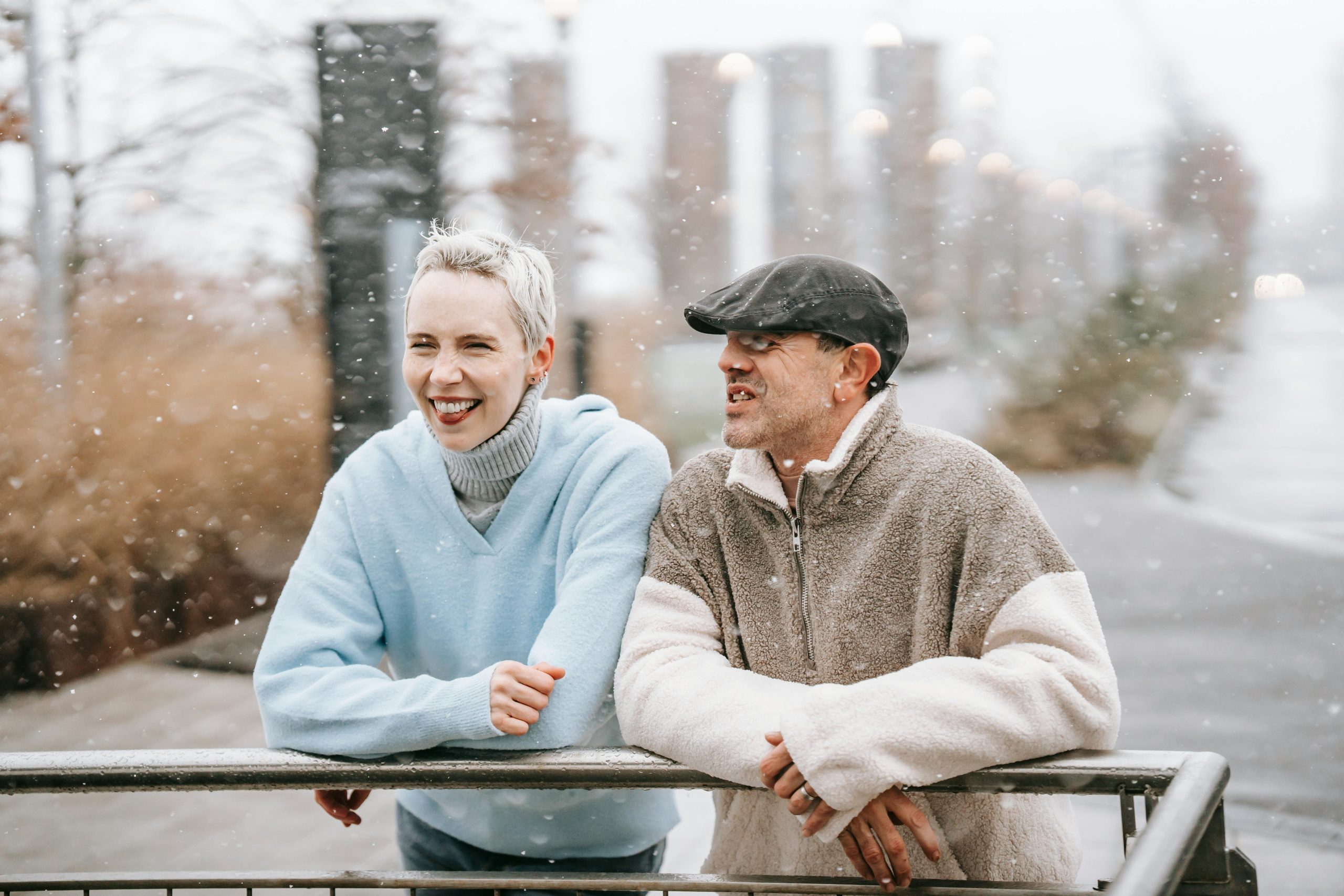 A happy couple laughing together where female partner wears minimal base makeup