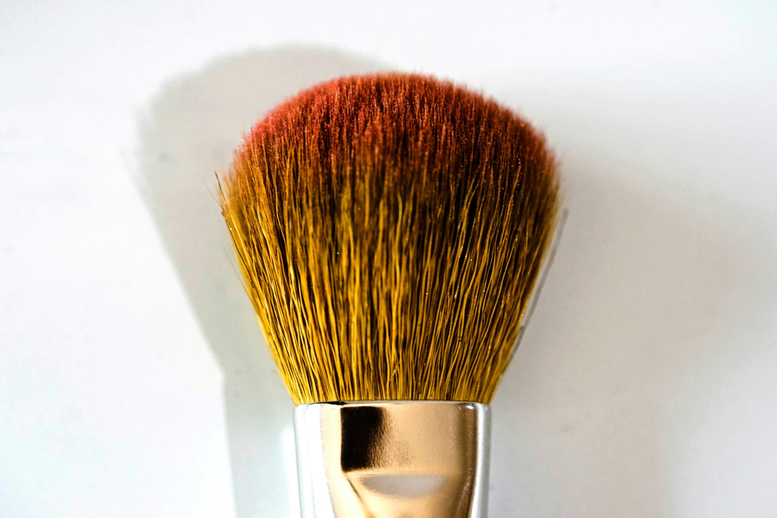 Person applying eco-friendly makeup using fingertips and reusable brush.
