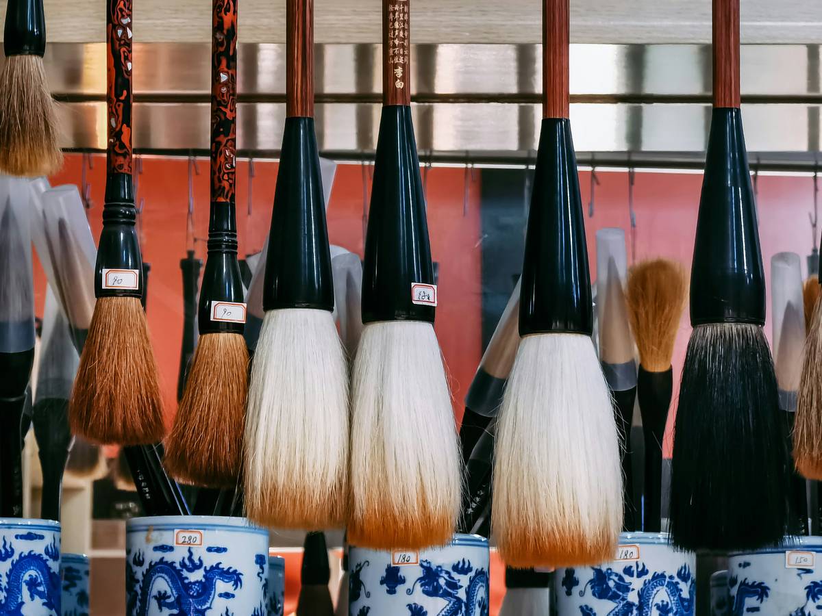 A set of bamboo-handled sustainable makeup brushes on a white table