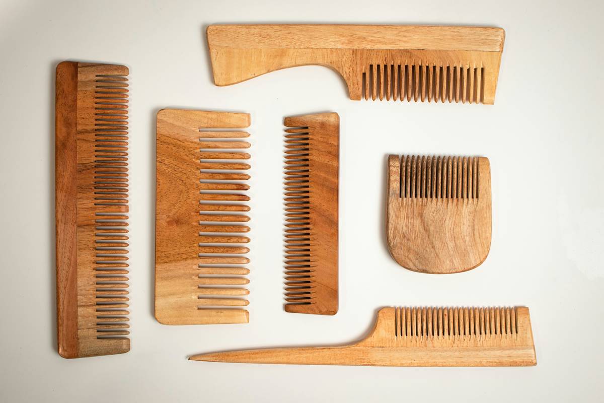 A woman applying makeup with sustainable brushes, smiling into the mirror