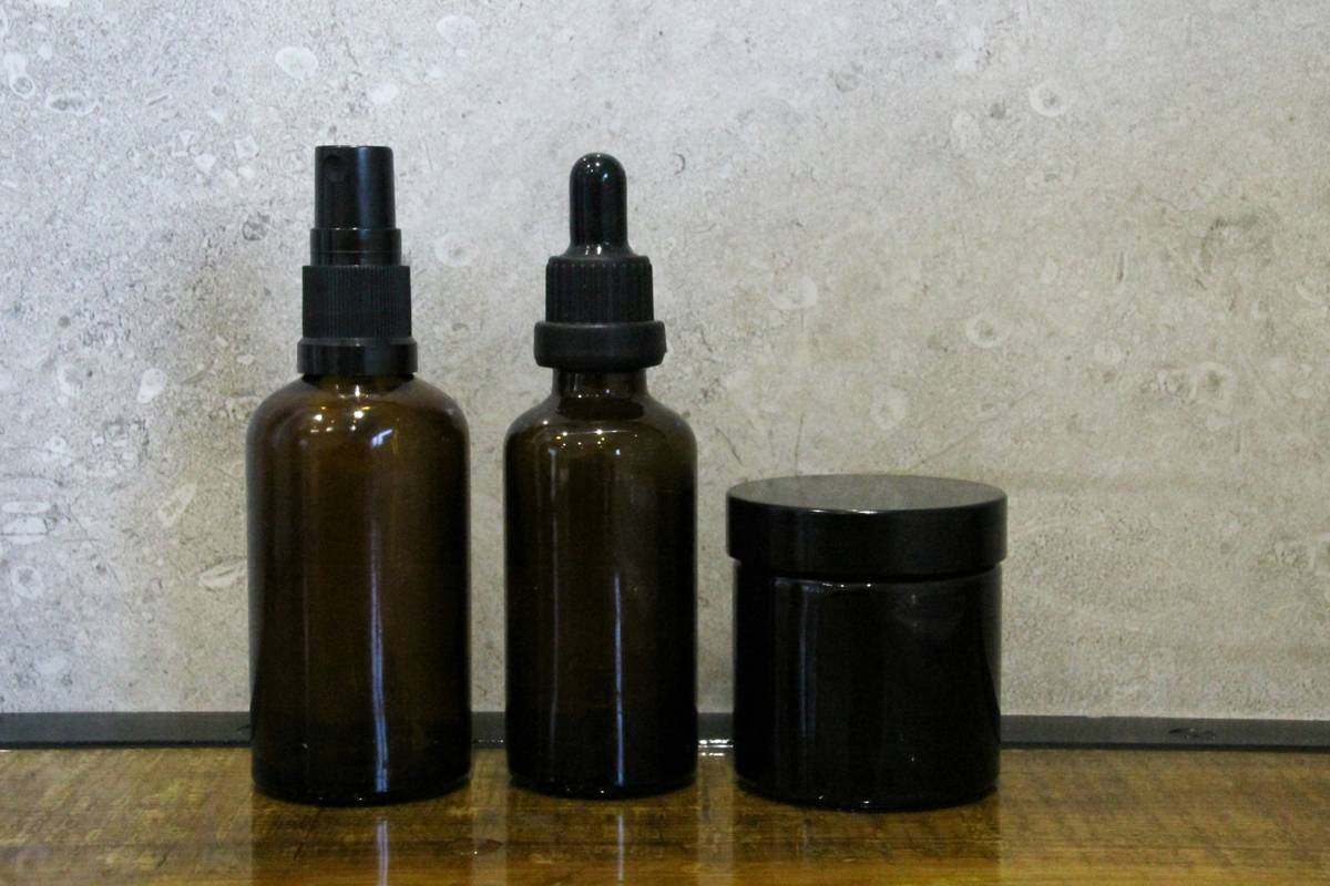 An array of organic makeup products including foundation, blush, and lipstick laid out neatly on a wooden table.