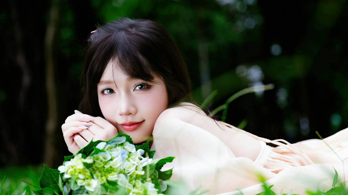 Eco beauty influencer applying natural makeup while surrounded by green plants